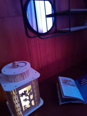a table with a lamp and a book next to a window at Sofia Zen - on Metro, ultra fast Wi-Fi in Sofia