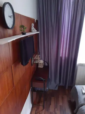 a room with a clock on a wall and a desk at Sofia Zen - on Metro, ultra fast Wi-Fi in Sofia