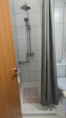 a bathroom with a shower with a curtain and a rug at Studio in Cedar Lodge 3 in Bansko