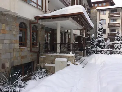 a house covered in snow with a pile of snow at Studio in Cedar Lodge 3 in Bansko
