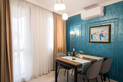a dining room with blue walls and a table and chairs at Odrys Apartments in Plovdiv