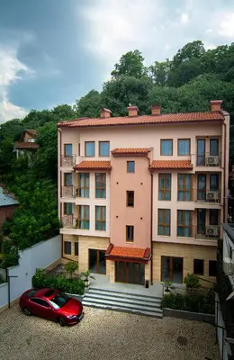 a red car parked in front of a building at Odrys Apartments in Plovdiv