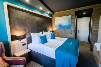 a bedroom with a large bed with blue pillows at Grande Vista Resort & Spa in Tsigov Chark