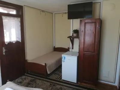 a small room with a small bed and a small refrigerator at Guest Rooms Dona in Koprivshtitsa