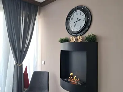 a clock over a fireplace with a clock above it at Premium StudioApartment in Borovets Gardens in Borovets