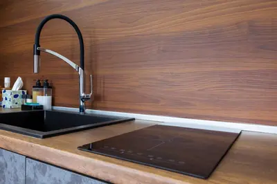 a kitchen with a black sink and a wooden wall at View apartment #1 in Bansko