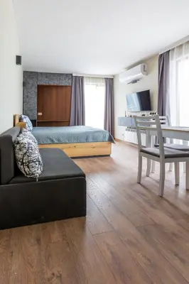 a bedroom with a bed and a couch and a table at View apartment #1 in Bansko
