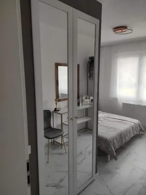 a bedroom with a mirror and a bed and a chair at Wellnesshouse Müller in Ilindentsi