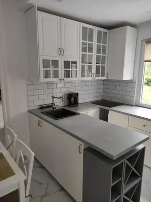 a kitchen with white cabinets and a sink at Wellnesshouse Müller in Ilindentsi