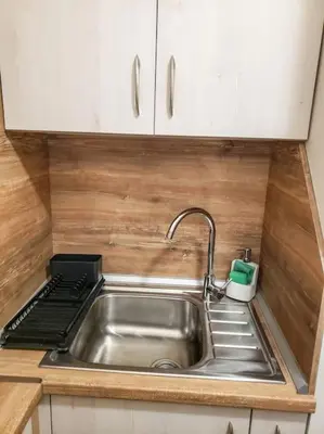 a stainless steel sink in a kitchen with white cabinets at Studio A10 Borovets gardens in Borovets
