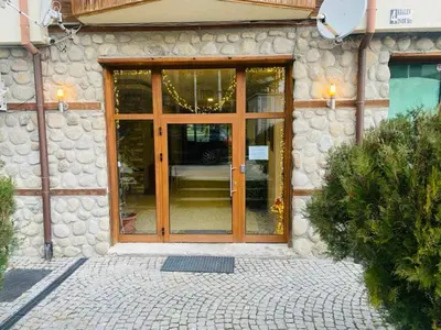 a stone building with a glass door with a sign in front at Apartment in Bansko, very close to the Gondola in Bansko