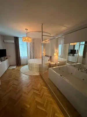 a large bathroom with a tub and a bed at Luxury apartment with Jacuzzi in Sofia