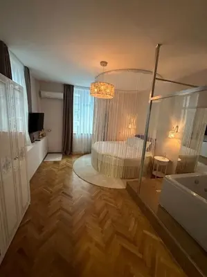 a large bedroom with a bed and a mirror at Luxury apartment with Jacuzzi in Sofia