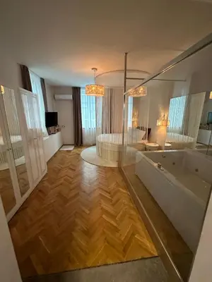 a large bathroom with a tub and a room with a couch at Luxury apartment with Jacuzzi in Sofia