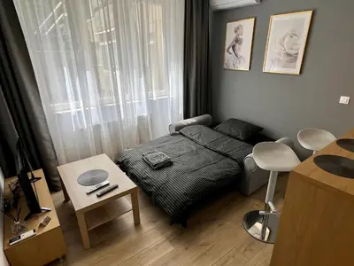 a small bedroom with a bed and a table at LOCATION ! Sofia Opera Apartment next to ALEXANDER NEVSKY CATHEDRAL in Sofia