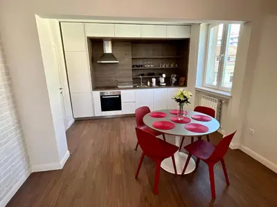 a kitchen and dining room with a table and red chairs at LOCATION ! LOCATION ! LOCATION ! City Garden View Apartment in Sofia