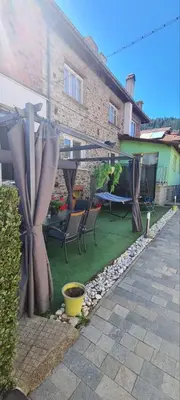 a backyard with a patio with chairs and a table at Апартаменти Сънрайс Чепеларе in Chepelare