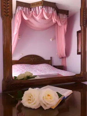 a bedroom with a bed with roses on a table at Elena Hotel in Petrich