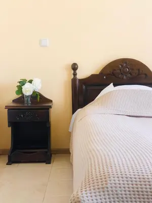 a bedroom with a bed and a table with a vase of flowers at Elena Hotel in Petrich