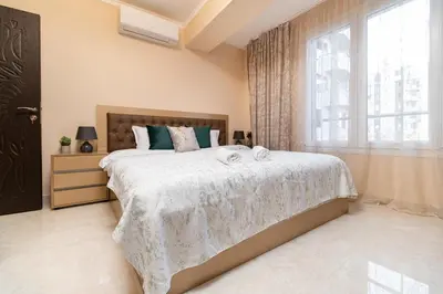 a bedroom with a large bed and a window at Modern & Elegant City Center Apartments in Plovdiv