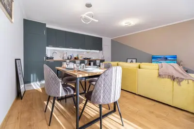 a living room with a table and a yellow couch at Modern & Elegant City Center Apartments in Plovdiv