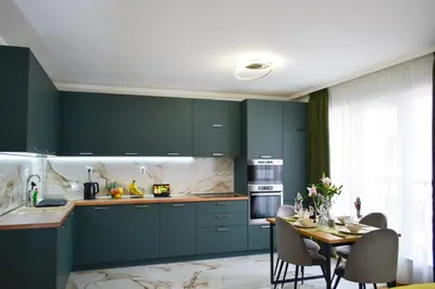 a kitchen with green cabinets and a table with chairs at Modern & Elegant City Center Apartments in Plovdiv