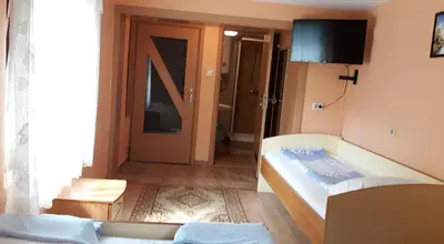 a bedroom with a bed and a room with a door at Guest House Rusalka in Shipkovo