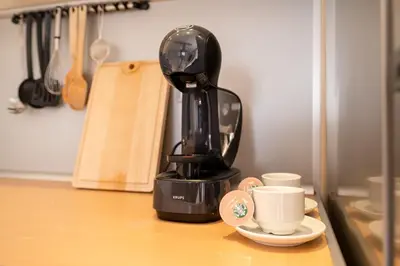 a coffee maker sitting on top of a counter with two cups at Spacious apartment in the city center in Plovdiv