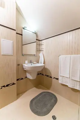 a bathroom with a sink and a mirror and a rug at Spacious apartment in the city center in Plovdiv
