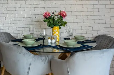 a dining room table with a vase of flowers on it at Top Central Maisonette with Underground parking in Sofia