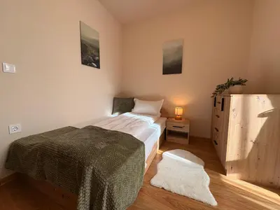 a bedroom with a bed and a dresser at Two-bedroom Apartments - Tundza in Sofia