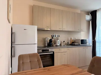 a kitchen with wooden cabinets and a white refrigerator at Two-bedroom Apartments - Tundza in Sofia
