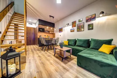 a living room with a green couch and a table at Deer Lake 521 at Oak Residence Hotel & Relax in Smolyan