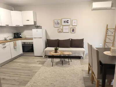 a kitchen and a living room with a couch and a table at Cozy home next to Aliosha - Boho Stay in the heart of Plovdiv in Plovdiv