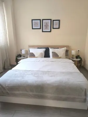 a bedroom with a large white bed with three pictures on the wall at Cozy home next to Aliosha - Boho Stay in the heart of Plovdiv in Plovdiv