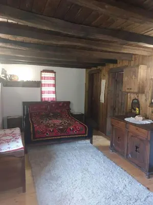 a bedroom with a bed and a table in a room at Къща за гости КИМ in Apriltsi