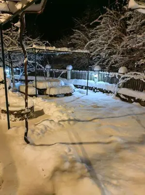 a yard covered in snow with a fence at Къща за гости КИМ in Apriltsi