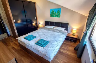 a bedroom with a bed with two pillows on it at Мансарда с фантастични гледки и две спални in Chepelare