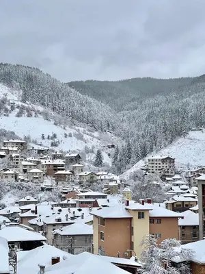 a town covered in snow with houses and trees at Мансарда с фантастични гледки и две спални in Chepelare