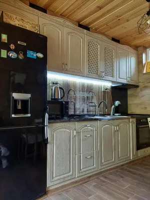 a kitchen with wooden cabinets and a black refrigerator at Green View 1 in Skrino