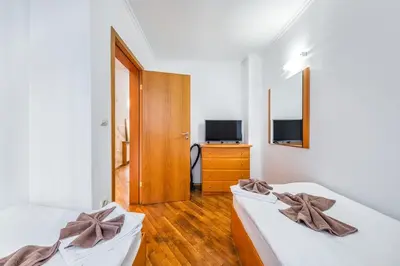 a bedroom with two beds and a television in it at Sofia University Life Apartment in Sofia