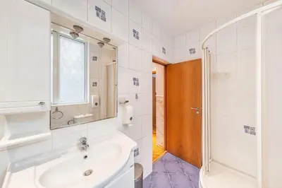 a bathroom with a sink and a mirror and a shower at Sofia University Life Apartment in Sofia