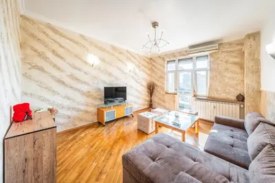 a living room with a couch and a tv at Sofia University Life Apartment in Sofia