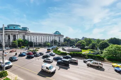 a parking lot filled with cars in front of a building at Sofia University Life Apartment in Sofia