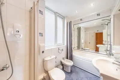 a bathroom with a toilet and a sink and a mirror at Sofia University Life Apartment in Sofia