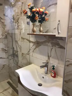 a bathroom with a sink and flowers on a shelf at Urban Comfort 1BR near South Park with Balcony in Sofia