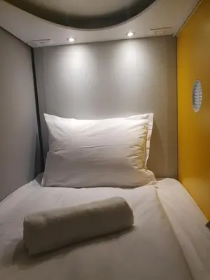 a white bed with a pillow on top of it at Green Cube Capsule Hostel in Sofia