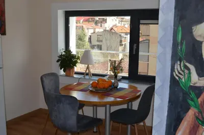 a dining room with a table and chairs and a window at Artistic loft with AMAZING VIEW in Plovdiv