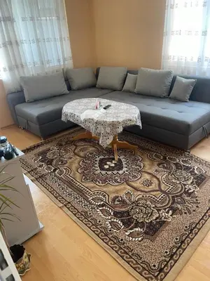 a living room with a couch and a table at Къща Бети самостоятелни апартаменти с двор край Пловдив in Skutare