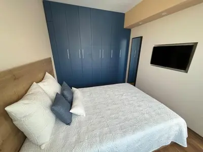 a bedroom with a bed with a blue wall at Cozy and bright apartment in Sofia